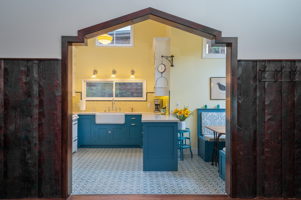 Small farmhouse u-shaped cement tile floor and blue floor eat-in kitchen photo in Los Angeles with a farmhouse sink, beaded inset cabinets, blue cabinets, quartz countertops, yellow backsplash, subway tile backsplash, white appliances and white countertops