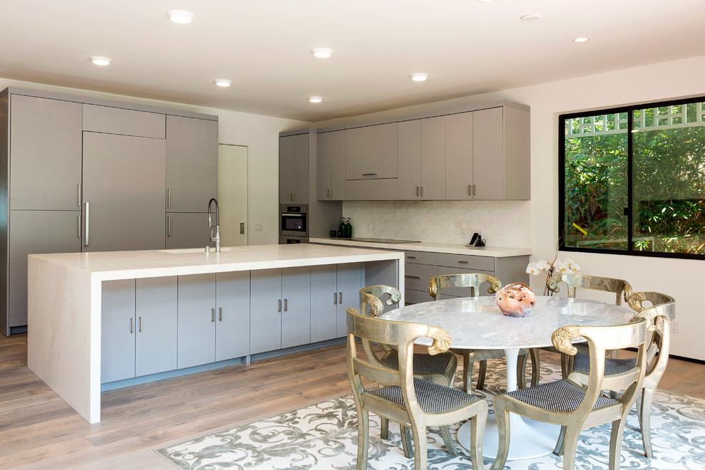 Inspiration for a contemporary l-shaped open plan kitchen in Los Angeles with flat-panel cabinets, grey cabinets, white splashback, integrated appliances, dark hardwood flooring and an island.