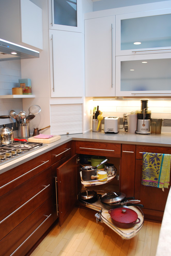 Immagine di una cucina contemporanea di medie dimensioni con lavello sottopiano, ante lisce, ante bianche, top in quarzite, paraspruzzi grigio, paraspruzzi con piastrelle di vetro, elettrodomestici in acciaio inossidabile e parquet chiaro