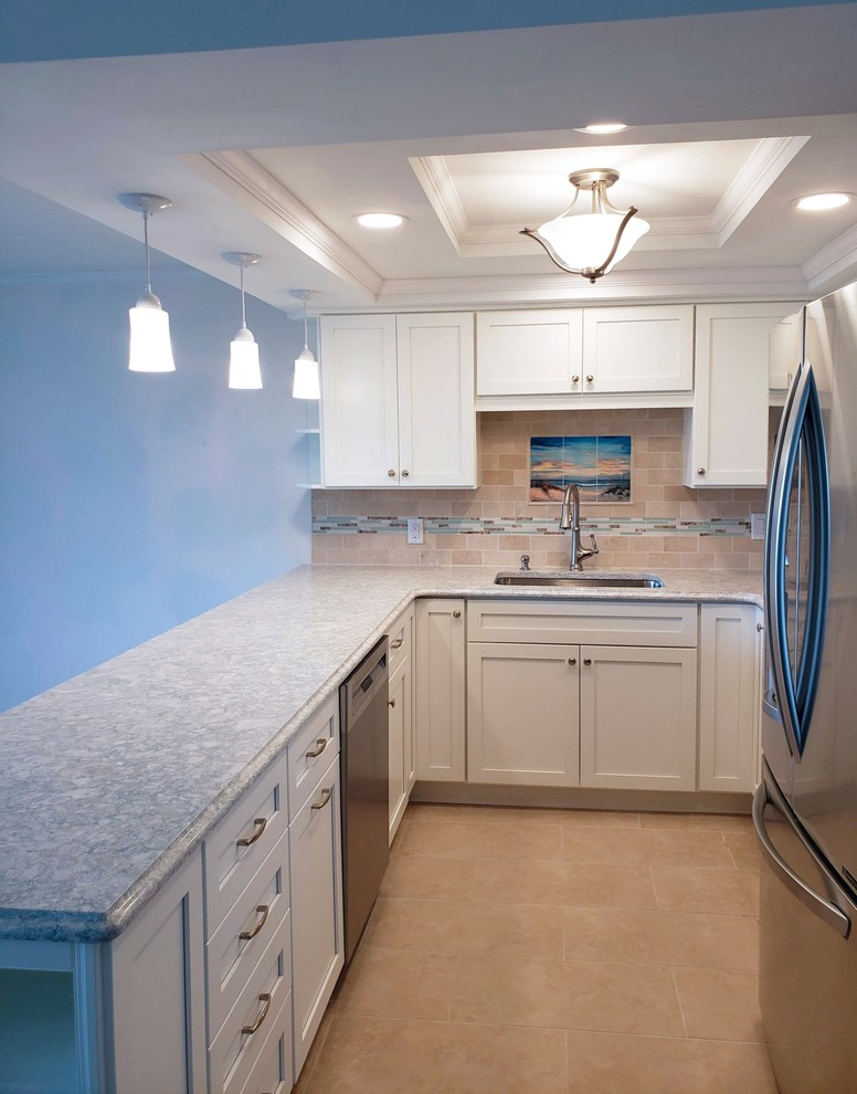 This is an example of a small nautical galley kitchen in Other with a single-bowl sink, shaker cabinets, white cabinets, engineered stone countertops, multi-coloured splashback, stainless steel appliances, a breakfast bar and beige floors.