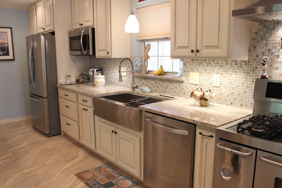 Exempel på ett mellanstort maritimt kök, med en rustik diskho, luckor med upphöjd panel, vita skåp, granitbänkskiva, flerfärgad stänkskydd, stänkskydd i glaskakel, rostfria vitvaror, klinkergolv i porslin och en köksö