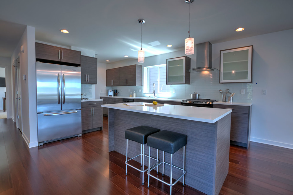 Inspiration for a small contemporary galley dark wood floor and brown floor eat-in kitchen remodel in Seattle with an undermount sink, flat-panel cabinets, brown cabinets, solid surface countertops, green backsplash, glass tile backsplash, stainless steel appliances and an island