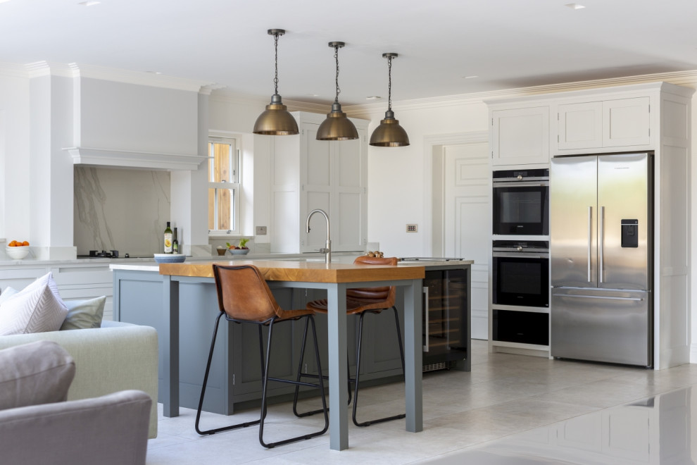 Design ideas for a large traditional open plan kitchen in Buckinghamshire with shaker cabinets, quartz worktops, white splashback, engineered quartz splashback, an island, grey floors and white worktops.
