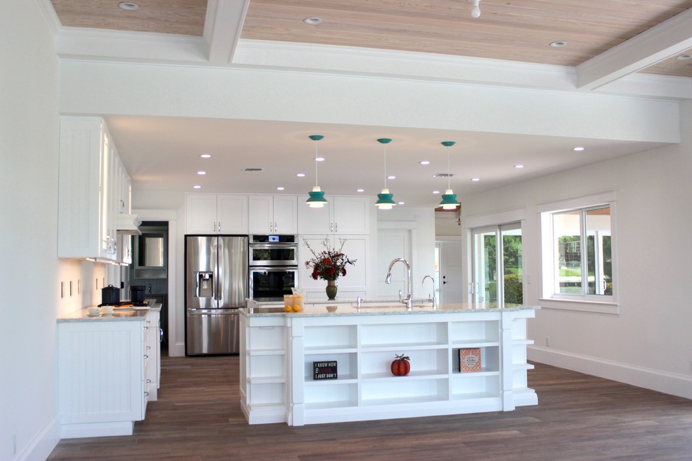 Exempel på ett stort modernt linjärt kök med öppen planlösning, med vita skåp, bänkskiva i kvarts, vitt stänkskydd, rostfria vitvaror, flera köksöar, skåp i shakerstil och laminatgolv