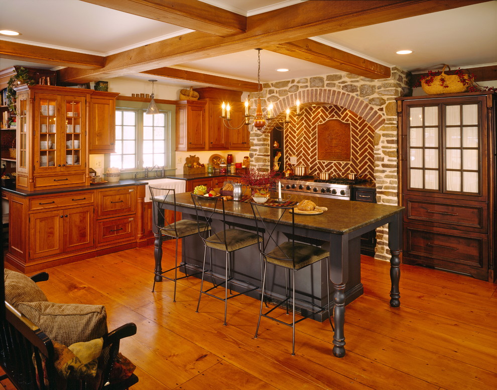 Urige Küche in L-Form mit Landhausspüle, hellbraunen Holzschränken und Mauersteinen in Newark
