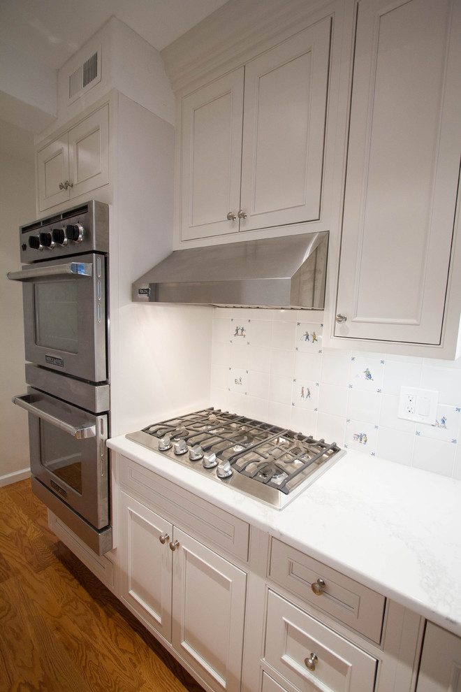 This is an example of a small classic galley enclosed kitchen in Philadelphia with a submerged sink, beaded cabinets, beige cabinets, engineered stone countertops, beige splashback, ceramic splashback, stainless steel appliances, medium hardwood flooring, no island and orange floors.