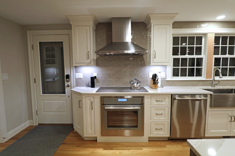 Idéer för att renovera ett mellanstort vintage vit linjärt vitt kök och matrum, med en rustik diskho, luckor med profilerade fronter, vita skåp, bänkskiva i kvarts, grått stänkskydd, stänkskydd i keramik, rostfria vitvaror, ljust trägolv, en köksö och gult golv