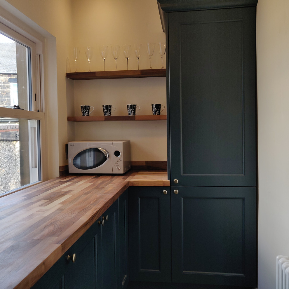 Medium sized country kitchen/diner in Other with a belfast sink, beaded cabinets, blue cabinets, wood worktops, brick flooring and a breakfast bar.