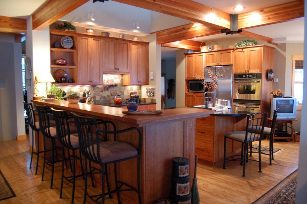 Bild på ett rustikt kök, med rostfria vitvaror, skåp i shakerstil, skåp i mellenmörkt trä, flerfärgad stänkskydd och stänkskydd i skiffer