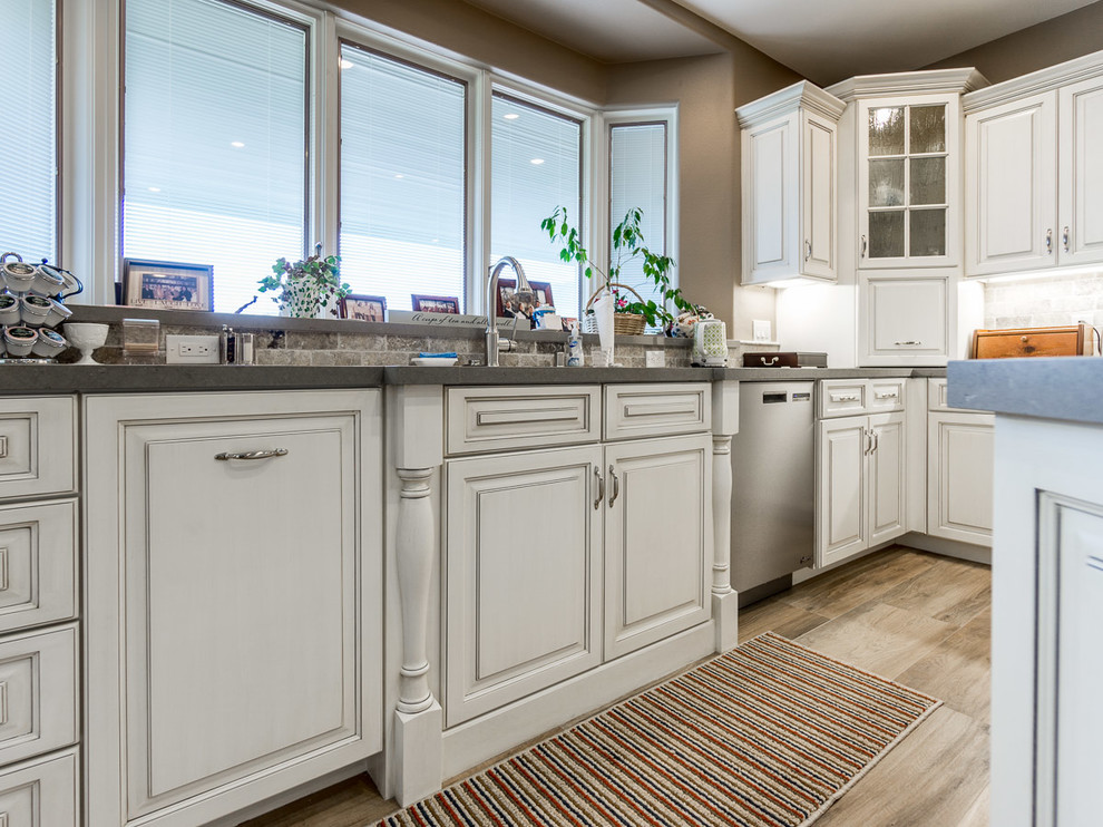 Idéer för att renovera ett stort vintage kök, med en enkel diskho, luckor med upphöjd panel, vita skåp, bänkskiva i kvartsit, beige stänkskydd, stänkskydd i travertin, rostfria vitvaror, klinkergolv i porslin, en köksö och flerfärgat golv