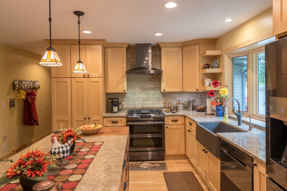 This is an example of a large classic l-shaped kitchen/diner in Minneapolis with a belfast sink, shaker cabinets, light wood cabinets, engineered stone countertops, beige splashback, brick splashback, stainless steel appliances, light hardwood flooring, an island, beige floors and beige worktops.