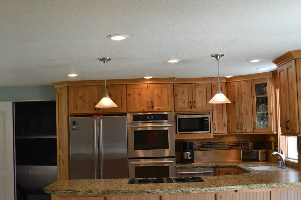 Foto på ett mellanstort rustikt kök, med granitbänkskiva, beige stänkskydd, rostfria vitvaror, en dubbel diskho, luckor med infälld panel, skåp i mellenmörkt trä, stänkskydd i keramik, klinkergolv i porslin och en halv köksö