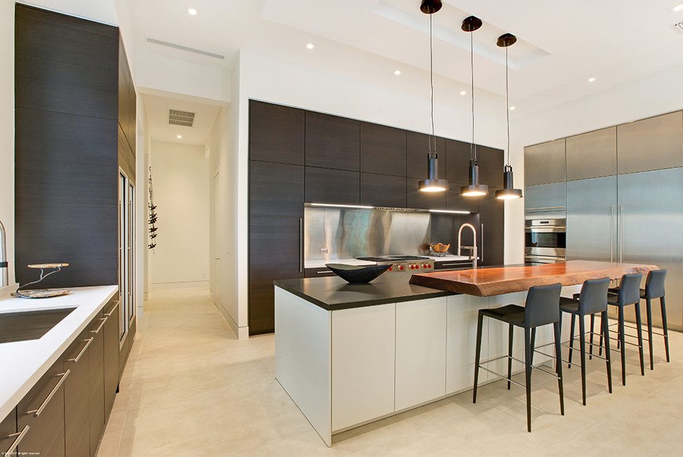 Example of a huge trendy u-shaped ceramic tile and beige floor open concept kitchen design in Miami with a single-bowl sink, flat-panel cabinets, dark wood cabinets, solid surface countertops, metallic backsplash, metal backsplash, stainless steel appliances and an island