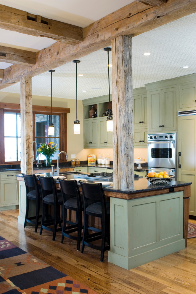 他の地域にあるラスティックスタイルのおしゃれなキッチン (パネルと同色の調理設備、落し込みパネル扉のキャビネット、緑のキャビネット) の写真