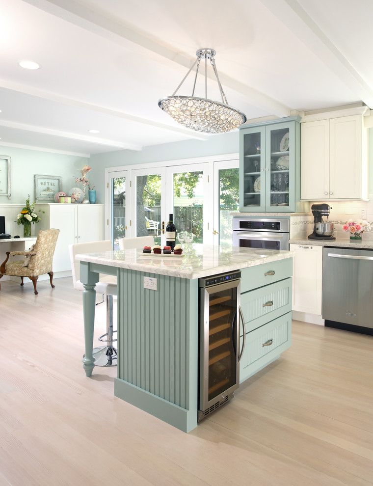 Large elegant l-shaped light wood floor eat-in kitchen photo in San Francisco with a farmhouse sink, shaker cabinets, white cabinets, marble countertops, white backsplash, ceramic backsplash, stainless steel appliances and an island