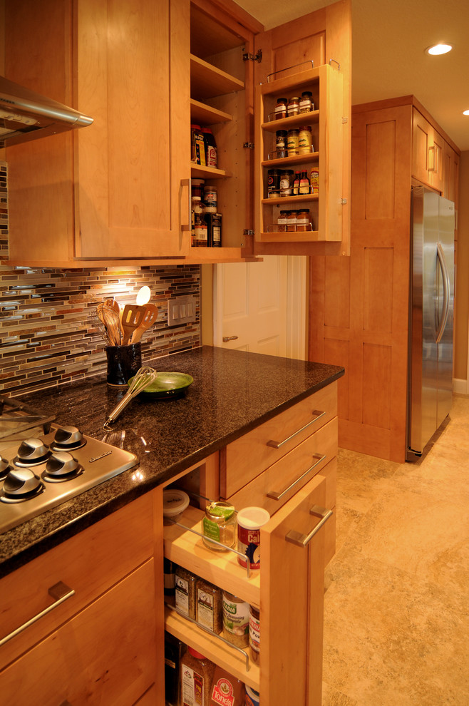 Klassisk inredning av ett kök, med skåp i shakerstil, skåp i mellenmörkt trä, stänkskydd i stickkakel, rostfria vitvaror och flerfärgad stänkskydd