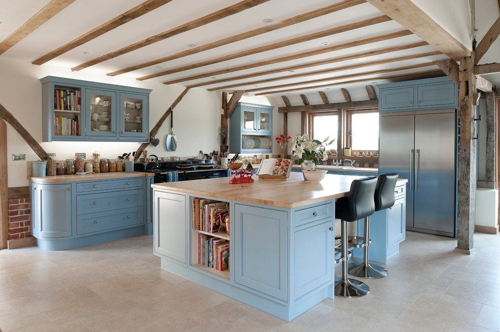 Große Country Küche in L-Form mit blauen Schränken, Arbeitsplatte aus Holz, schwarzen Elektrogeräten, Kücheninsel und Schrankfronten im Shaker-Stil in Kent