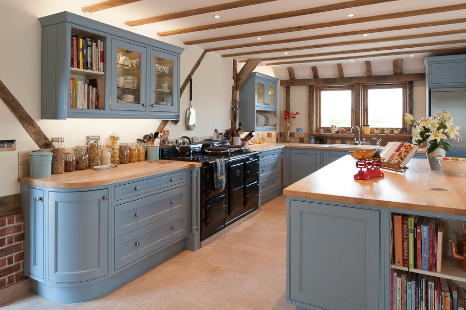 Große Country Wohnküche in L-Form mit blauen Schränken, Arbeitsplatte aus Holz, schwarzen Elektrogeräten und Kücheninsel in Kent