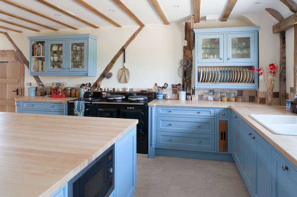 Große Landhaus Wohnküche in L-Form mit blauen Schränken, Arbeitsplatte aus Holz, schwarzen Elektrogeräten und Kücheninsel in Kent