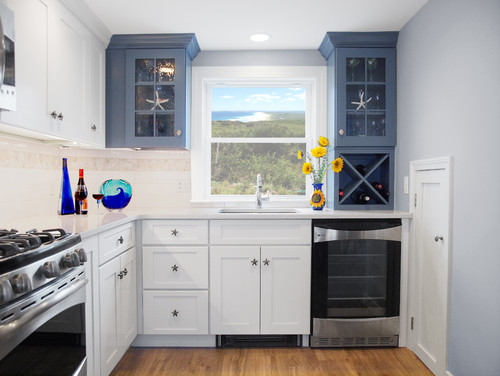 Compact Canadian kitchen with two-tone cabinets, featuring white shaker base units and navy blue glass-front uppers – a stylish choice among the best kitchen cabinet colors in Canada.