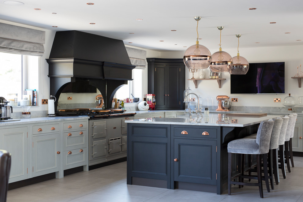 This is an example of a traditional galley kitchen in Other with recessed-panel cabinets, blue cabinets, coloured appliances, an island, grey floors and grey worktops.