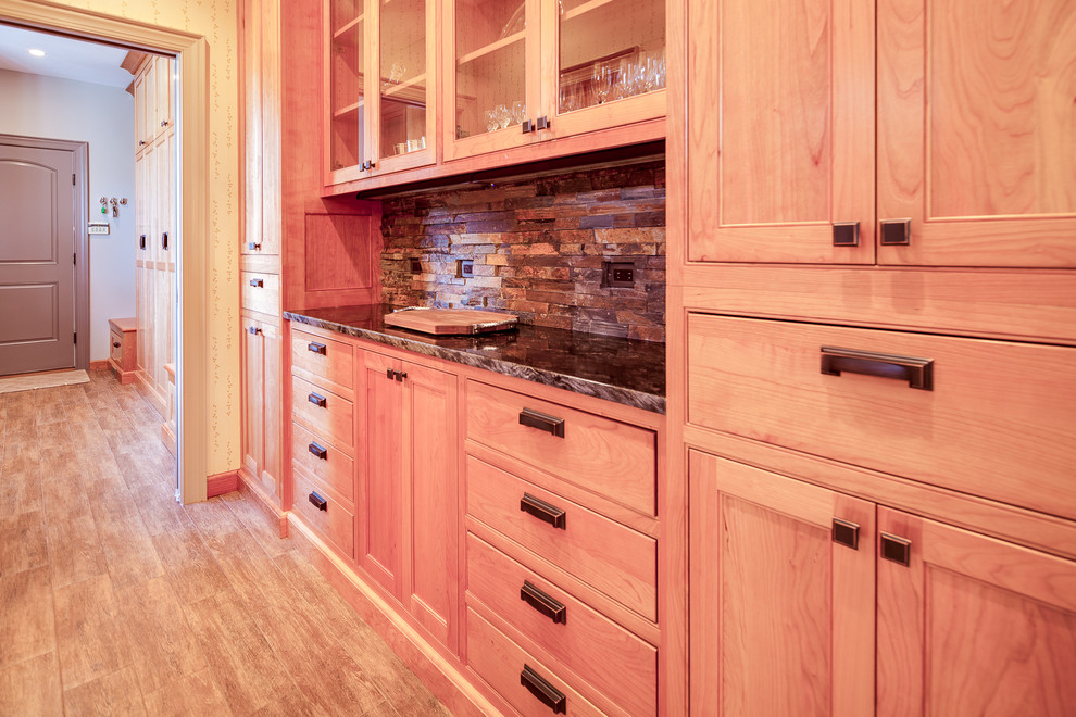 Inspiration for a large traditional single-wall kitchen pantry in DC Metro with a belfast sink, recessed-panel cabinets, medium wood cabinets, granite worktops, brown splashback, matchstick tiled splashback, stainless steel appliances, dark hardwood flooring and an island.
