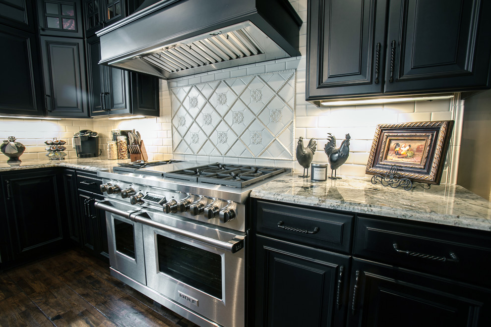 Large elegant u-shaped dark wood floor eat-in kitchen photo in St Louis with a farmhouse sink, raised-panel cabinets, black cabinets, granite countertops, white backsplash, subway tile backsplash, stainless steel appliances and an island