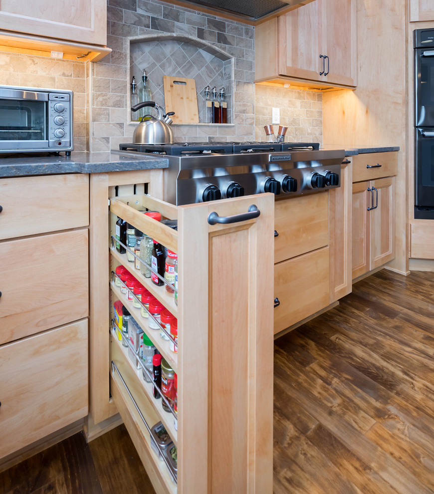 Exempel på ett stort klassiskt brun brunt kök, med en rustik diskho, luckor med upphöjd panel, skåp i mellenmörkt trä, träbänkskiva, beige stänkskydd, stänkskydd i porslinskakel, svarta vitvaror, ljust trägolv, en köksö och brunt golv