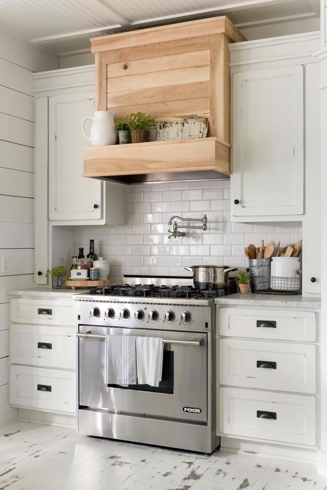 Exempel på ett mellanstort lantligt vit vitt kök, med en rustik diskho, vitt stänkskydd, målat trägolv, en köksö, vitt golv, luckor med infälld panel, stänkskydd i tunnelbanekakel och rostfria vitvaror