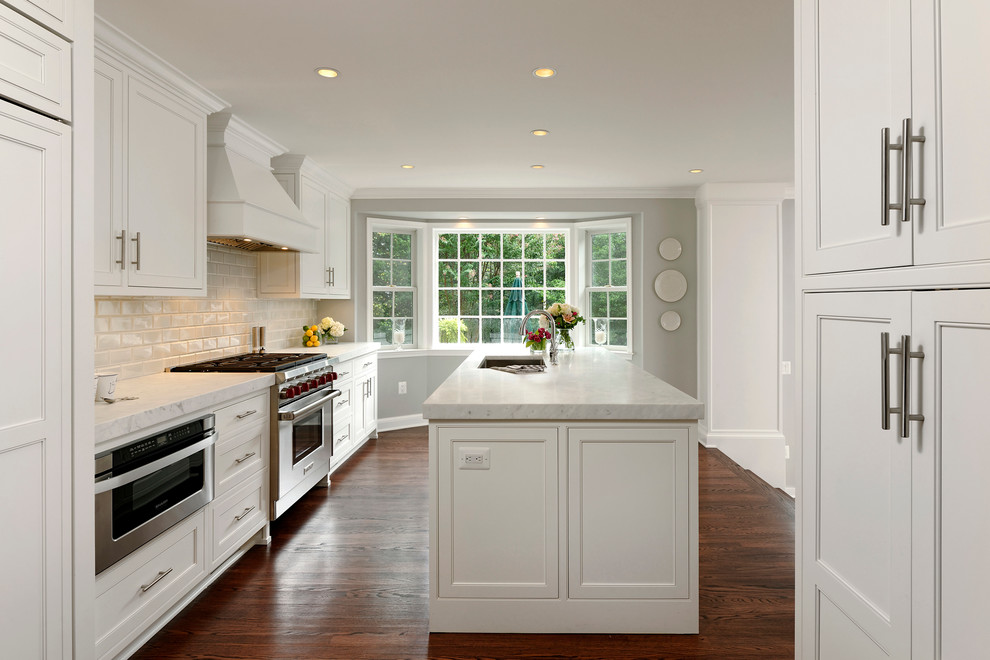 Esempio di un cucina con isola centrale design con ante bianche, top in marmo, paraspruzzi bianco, paraspruzzi con piastrelle diamantate e elettrodomestici in acciaio inossidabile