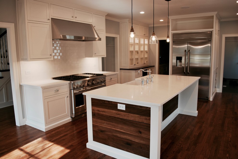 Exempel på ett mellanstort klassiskt kök, med vita skåp, en rustik diskho, luckor med infälld panel, marmorbänkskiva, vitt stänkskydd, stänkskydd i tunnelbanekakel, rostfria vitvaror, mörkt trägolv och en köksö