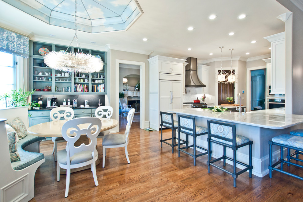 Example of a large transitional u-shaped medium tone wood floor and brown floor eat-in kitchen design in Nashville with a farmhouse sink, shaker cabinets, white cabinets, quartzite countertops, white backsplash, subway tile backsplash, stainless steel appliances, an island and multicolored countertops