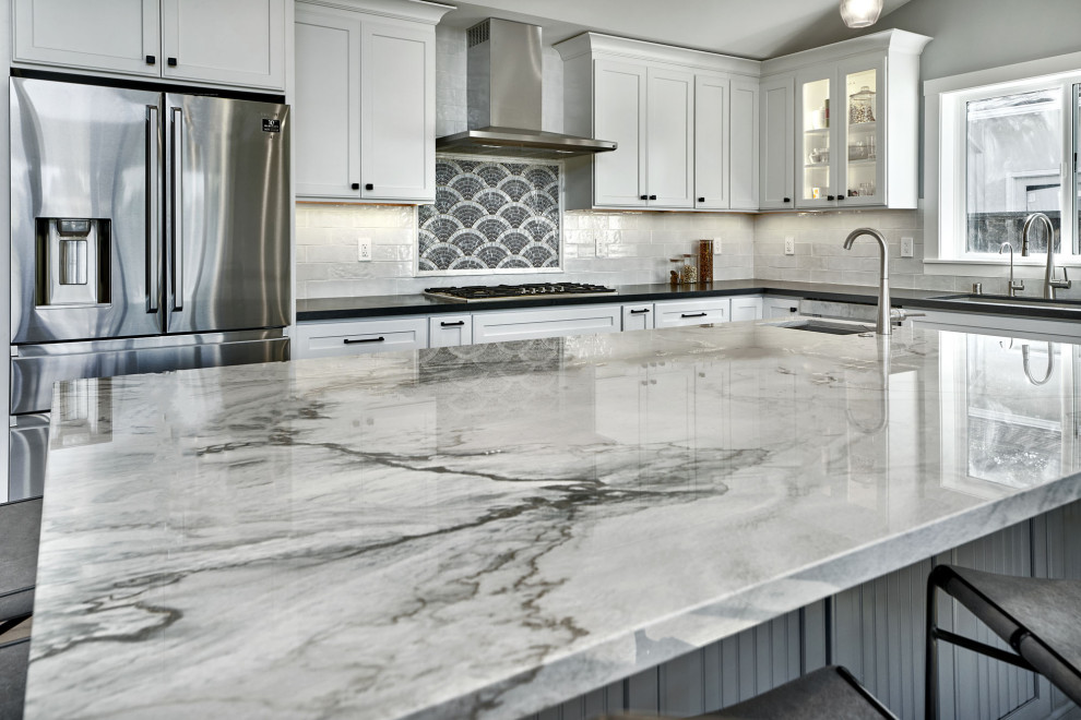 Large trendy l-shaped medium tone wood floor and multicolored floor open concept kitchen photo in San Francisco with an undermount sink, flat-panel cabinets, white cabinets, granite countertops, blue backsplash, ceramic backsplash, stainless steel appliances, an island and black countertops