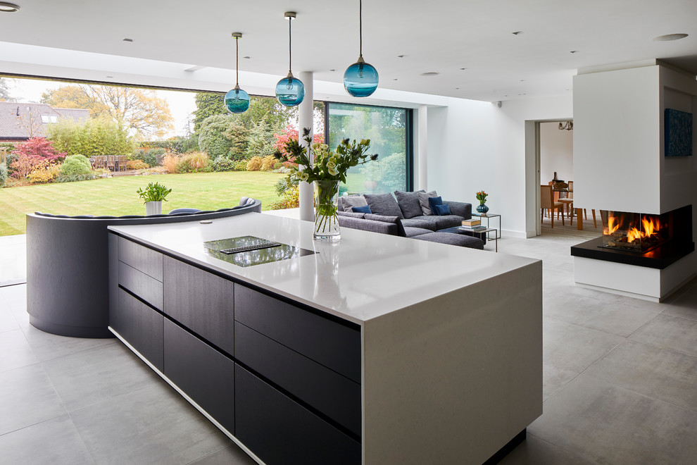 Foto di una cucina minimal con ante lisce, ante nere, elettrodomestici neri, pavimento in cemento, pavimento grigio e top beige