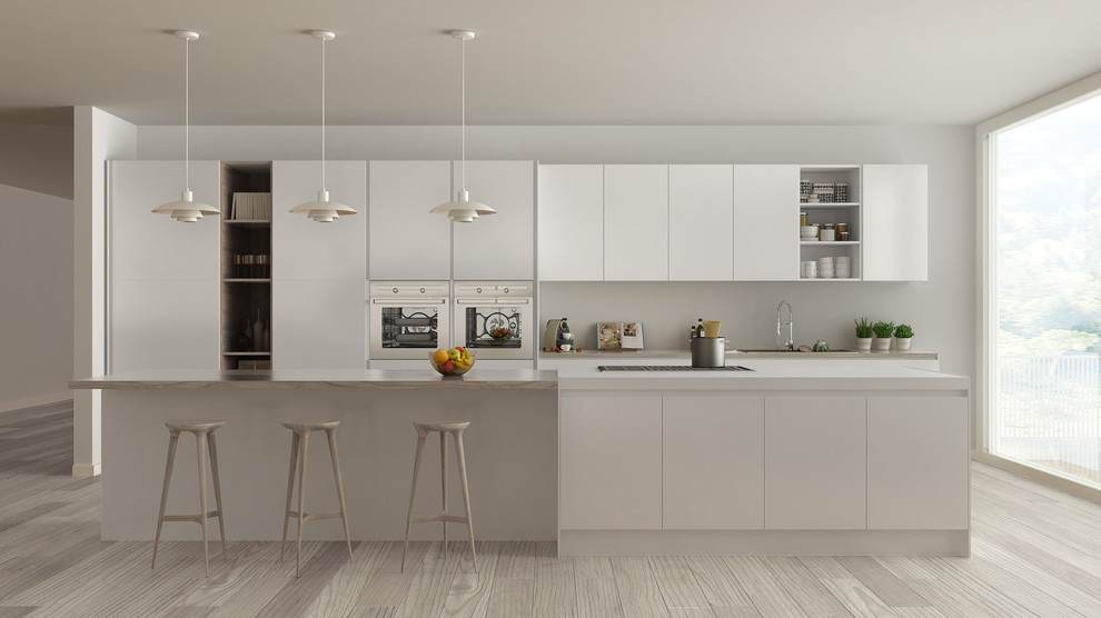 This is an example of a medium sized modern single-wall enclosed kitchen in Miami with a built-in sink, louvered cabinets, white cabinets, wood worktops, white splashback, porcelain splashback, stainless steel appliances, light hardwood flooring, an island and beige floors.