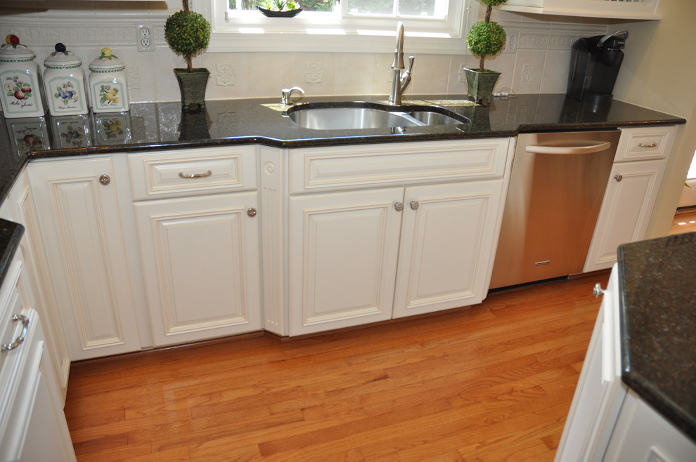 ワシントンD.C.にある広いコンテンポラリースタイルのおしゃれなキッチン (アンダーカウンターシンク、白いキャビネット、シルバーの調理設備) の写真