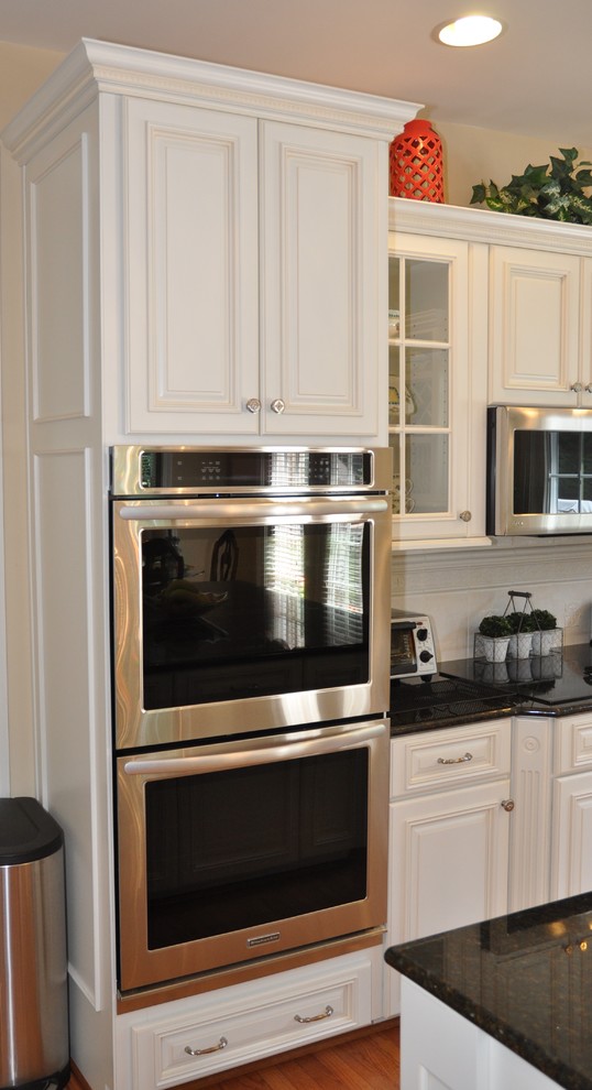 Modelo de cocina contemporánea grande con fregadero bajoencimera, puertas de armario blancas, electrodomésticos de acero inoxidable y una isla