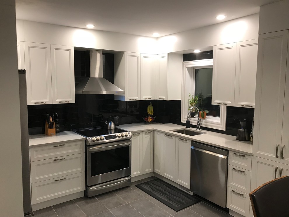 Inspiration for a mid-sized 1950s u-shaped ceramic tile and gray floor open concept kitchen remodel in Montreal with an undermount sink, beaded inset cabinets, white cabinets, quartzite countertops, black backsplash, ceramic backsplash, stainless steel appliances, no island and white countertops