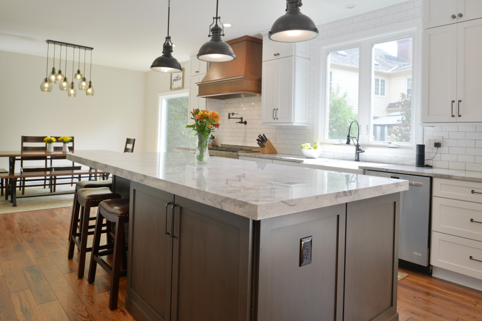Inspiration for a mid-sized contemporary light wood floor and beige floor eat-in kitchen remodel in DC Metro with a farmhouse sink, white cabinets, quartzite countertops, white backsplash, ceramic backsplash, stainless steel appliances, an island and white countertops