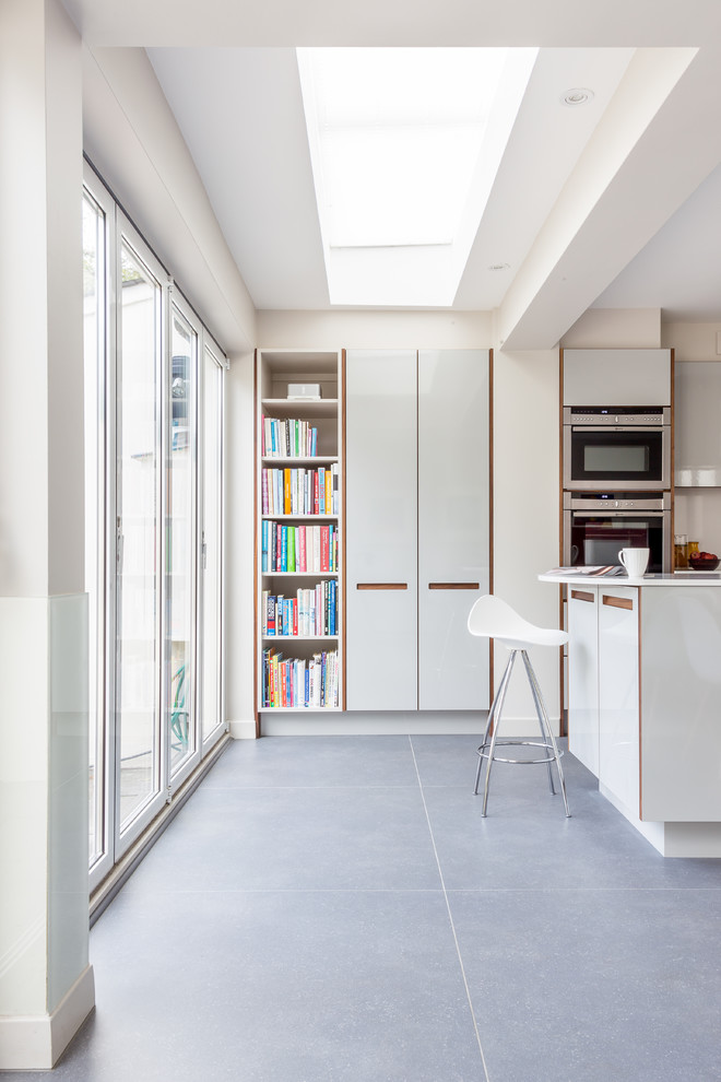 На фото: кухня в современном стиле с плоскими фасадами и серыми фасадами с