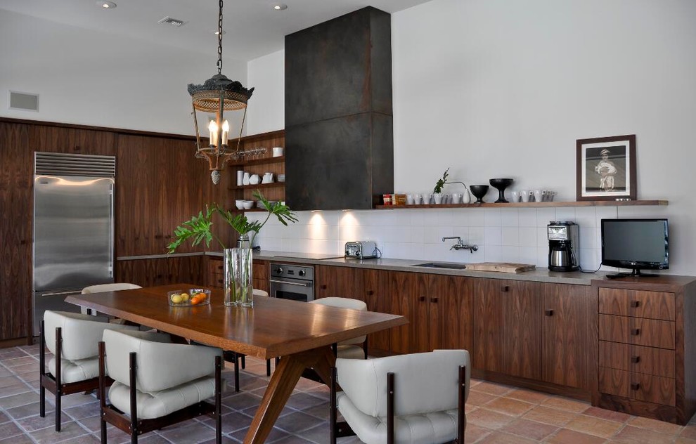 Photo of a medium sized modern l-shaped open plan kitchen in Los Angeles with a submerged sink, flat-panel cabinets, dark wood cabinets, engineered stone countertops, white splashback, ceramic splashback, stainless steel appliances, terracotta flooring, an island and beige floors.
