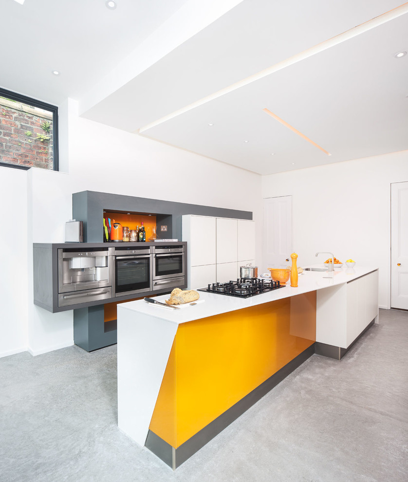 Zweizeilige, Große Moderne Wohnküche mit Waschbecken, flächenbündigen Schrankfronten, weißen Schränken, Küchenrückwand in Orange, Küchengeräten aus Edelstahl, Betonboden und Kücheninsel in Glasgow