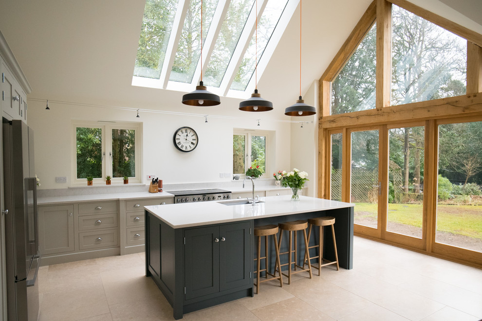 Design ideas for a large country kitchen/diner in Surrey with shaker cabinets, quartz worktops, an island, a submerged sink, grey cabinets, grey splashback, stainless steel appliances, beige floors and white worktops.