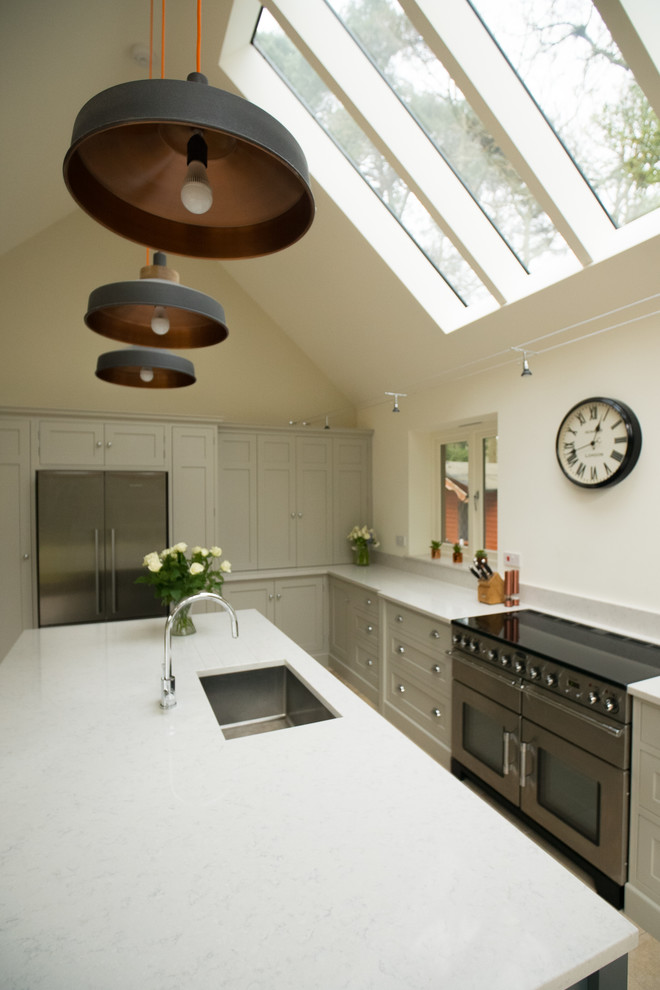 This is an example of a large contemporary kitchen/diner in Surrey with shaker cabinets, quartz worktops and an island.
