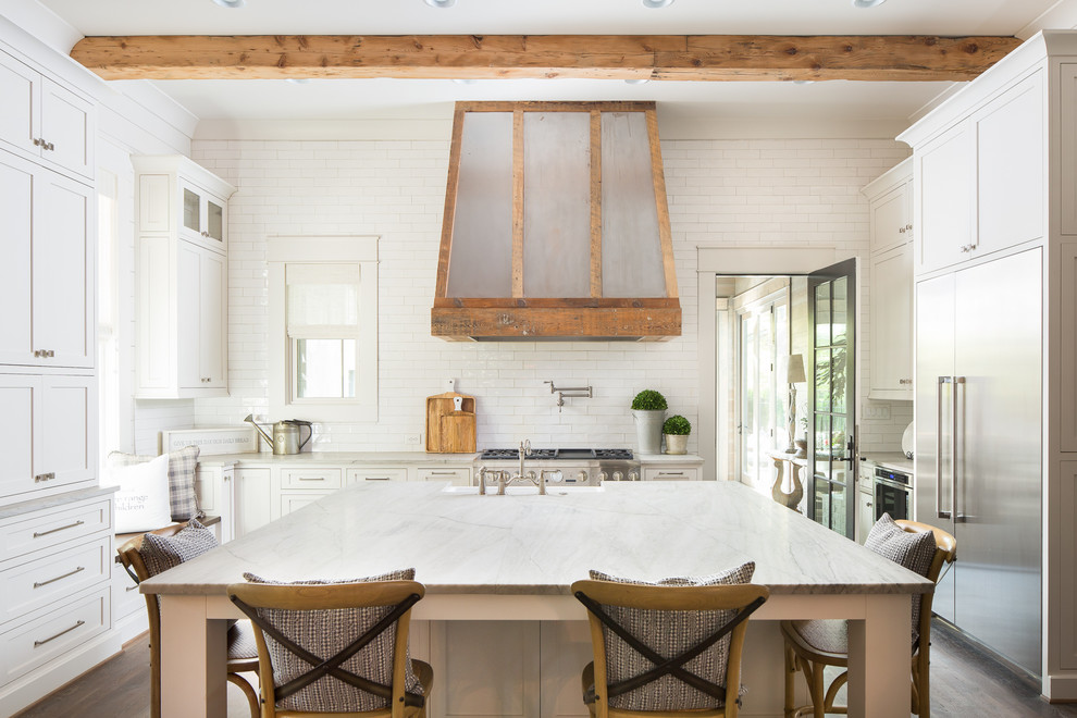 Example of a large cottage dark wood floor kitchen design in Atlanta with a farmhouse sink, white cabinets, marble countertops, white backsplash, subway tile backsplash, stainless steel appliances, an island and shaker cabinets