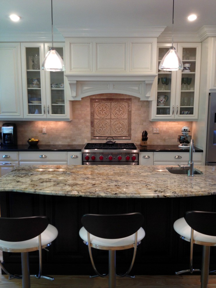 This is an example of a traditional kitchen in Raleigh with raised-panel cabinets, white cabinets, granite worktops, beige splashback, stainless steel appliances and light hardwood flooring.