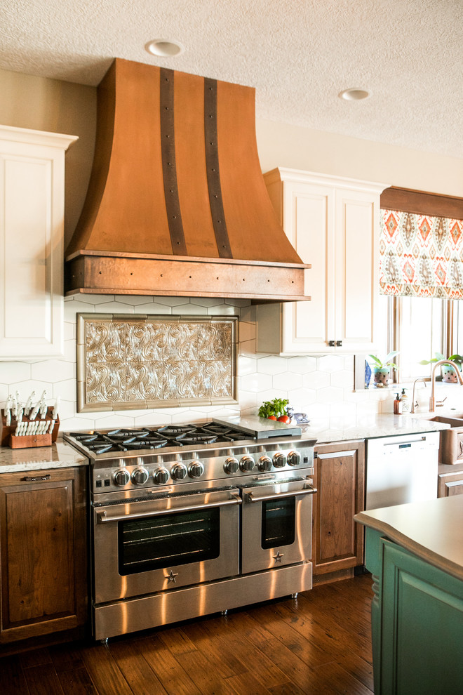 インディアナポリスにある高級な広いサンタフェスタイルのおしゃれなキッチン (エプロンフロントシンク、レイズドパネル扉のキャビネット、珪岩カウンター、白いキッチンパネル、磁器タイルのキッチンパネル、シルバーの調理設備、濃色無垢フローリング) の写真