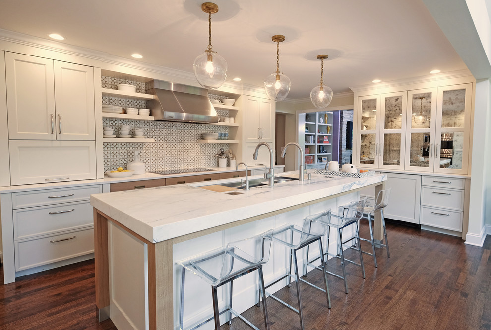 Example of a mid-sized transitional u-shaped medium tone wood floor eat-in kitchen design in Chicago with white cabinets, marble countertops, an island, an undermount sink, multicolored backsplash, ceramic backsplash and paneled appliances
