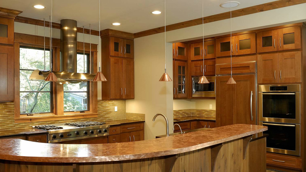 Immagine di una cucina abitabile stile americano con lavello stile country, ante in stile shaker, ante marroni, paraspruzzi con piastrelle di vetro e elettrodomestici in acciaio inossidabile