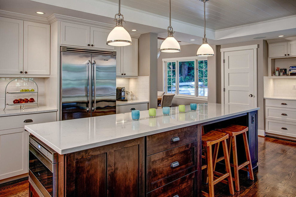 シアトルにある広いトラディショナルスタイルのおしゃれなアイランドキッチン (シェーカースタイル扉のキャビネット、白いキャビネット、白いキッチンパネル、サブウェイタイルのキッチンパネル、シルバーの調理設備) の写真
